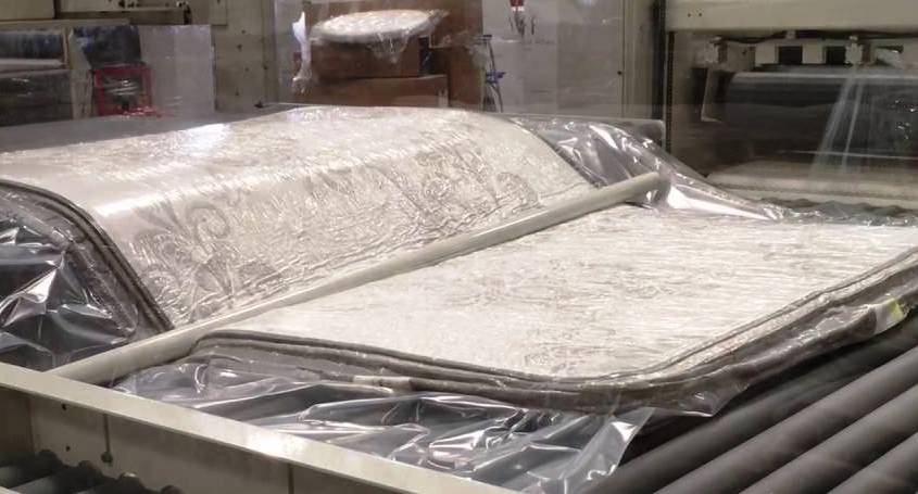 A compressed mattress being folded before roll packing